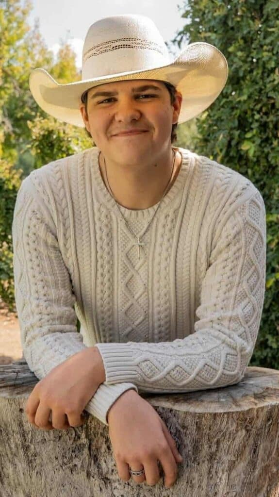 Young boy in beige sweater wearing cowboy hat