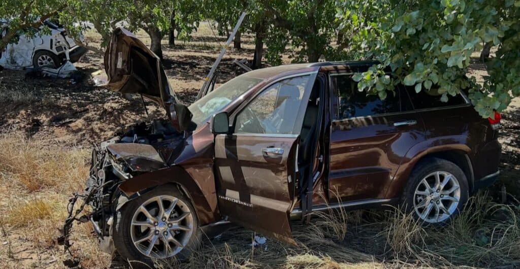 A Jeep Cherokee sits next to a pistachio tree after a collision on Avenue 21 and Road 28 1/2. The driver of a white Ford Escape (in background) died from the accident last week.