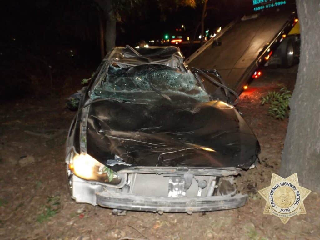 Photo - A Mitsubishi is ready to be lifted onto a tow truck after a solo crash Sunday night. The crash, off of State Route 99 and Madera Avenue, resulted in the fatality of the driver. There were no other passengers in the vehicle.