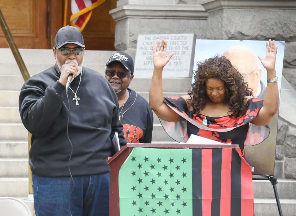 Photo - Pastor Charles Fryer delivers the closing prayer alongside Pastor Sammy Neely and then-Madera Mayor Pro Tem Anita Evans during the 2022 Juneteenth Celebration at Courthouse Park.