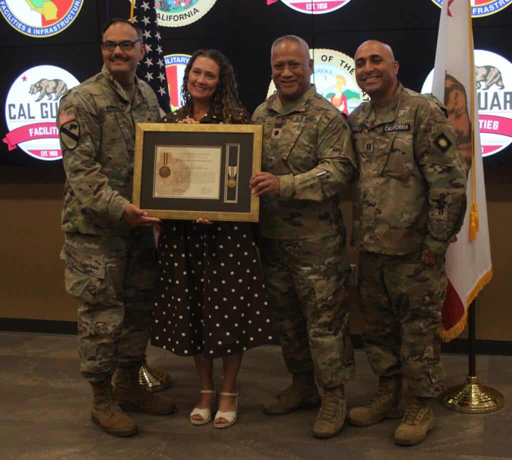 Photo - Melissa Pogue, an analyst for the State Military Department for the Army National Guard, receives an award with her former, and current, bosses. From left are Major Andrew Hernandez, Pogue, Lieutenant Colonel Jubilee Satele and Major Max Montellano.