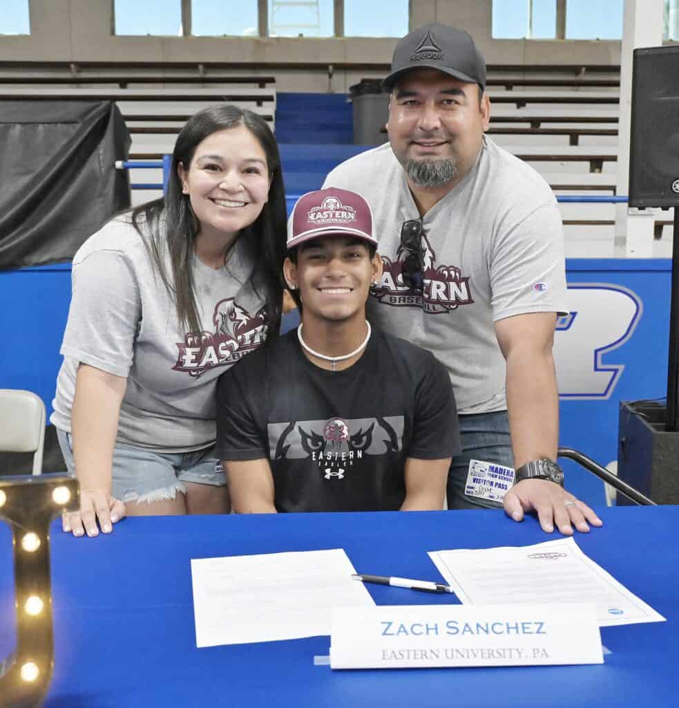 Photo - Madera Coyote baseball player Zach Sanchez is all smiles with his parents, Jerika and Allan Sanchez, after signing a National Letter of Intent to Eastern University in Pennsylvania.
