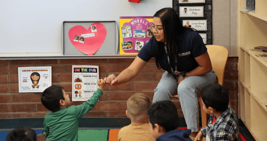 Teacher engaging preschool students in classroom activity.