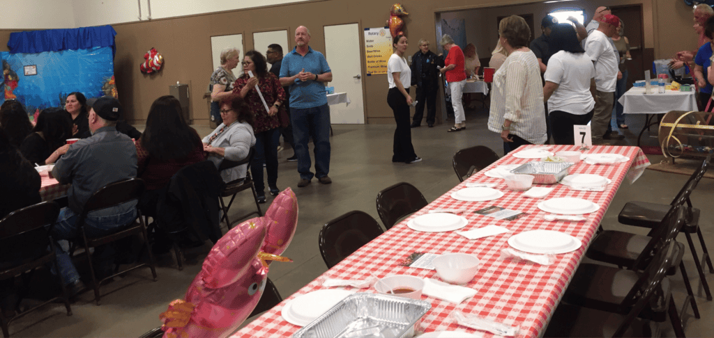Sunrise Rotary hosts community shrimp eating event with attendees enjoying seafood.