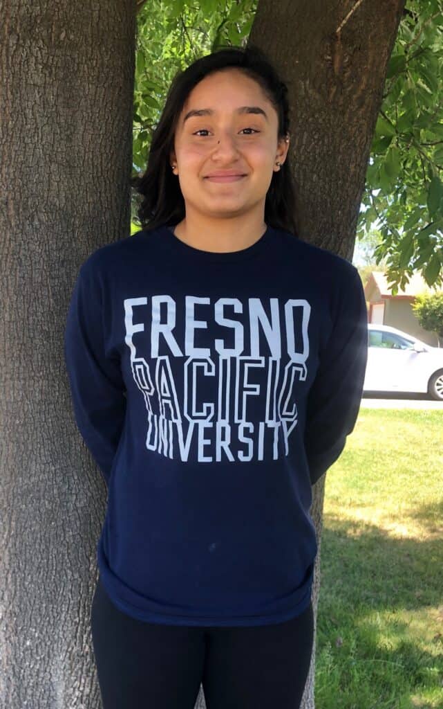 Lopez-Ibarra smiling outdoors near a tree at Fresno Pacific University.