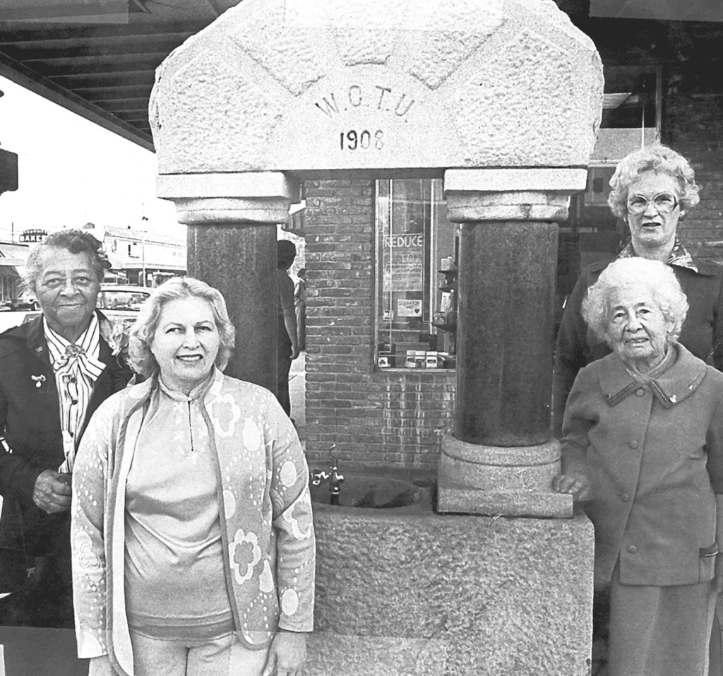 Group of women standing around the historic Madera fountain, built in 1908, in Madera, California.