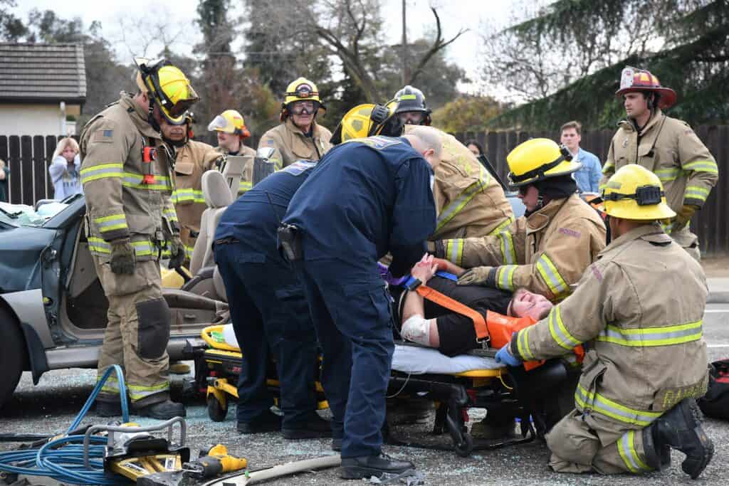 Firefighters and paramedics work together to rescue and provide medical aid.