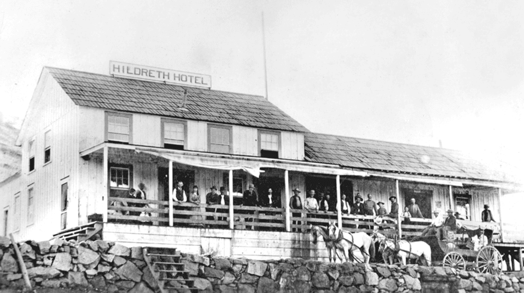 Historic photo of Hildreth Hotel with guests on the porch, Madera, California.