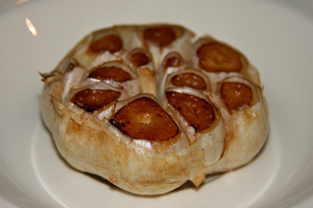 Roasted garlic mushrooms on a white plate, close-up.