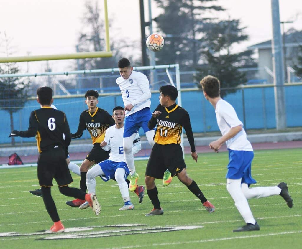 Madera High soccer players compete during a game on a sunny day.