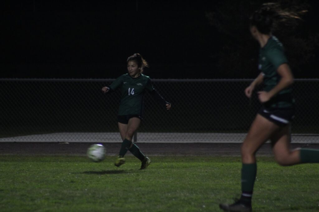 Liberty soccer players in action during night match.
