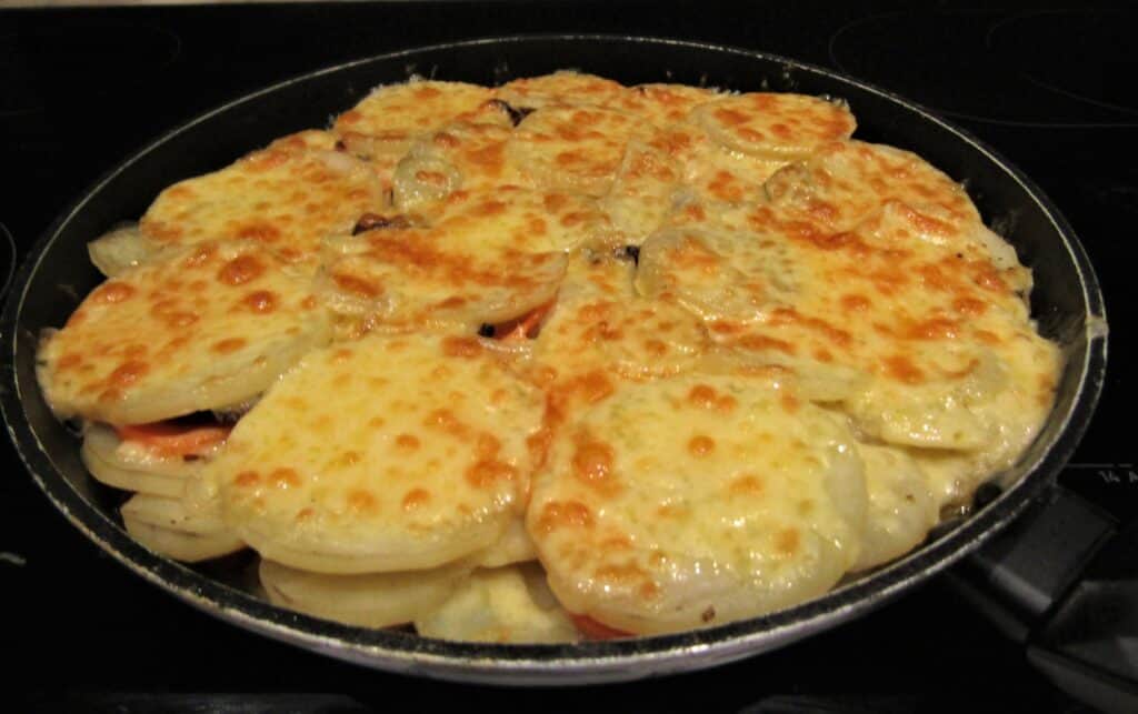 Delicious cheesy scalloped potatoes topped with melted cheese, perfect for holiday side dishes. A co.