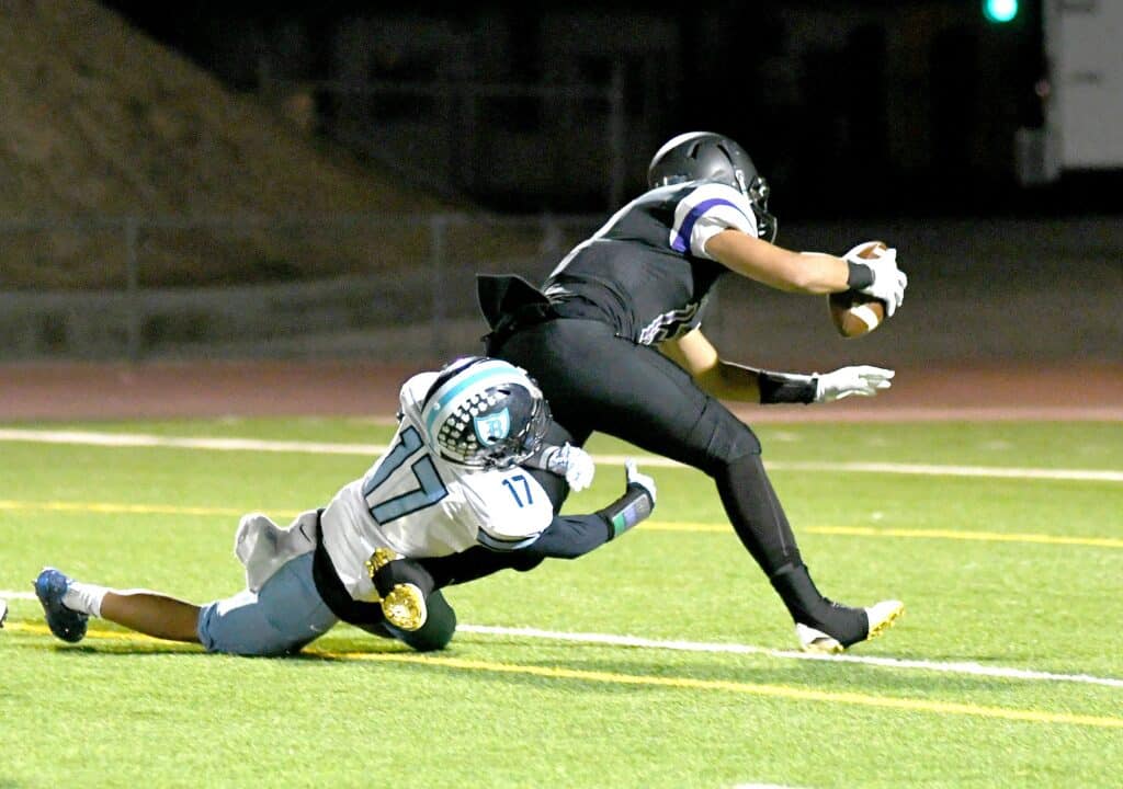 Madera Stallions player evades tackle during game at night.