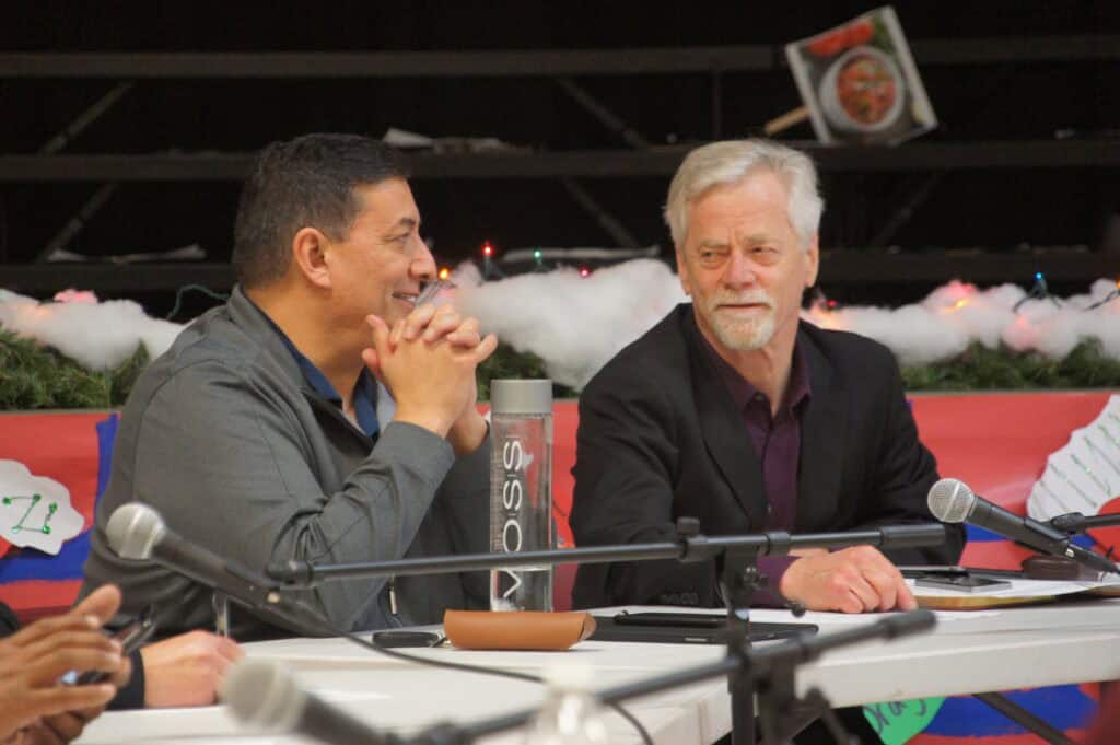 Two men discussing future plans at Chowchilla community event.