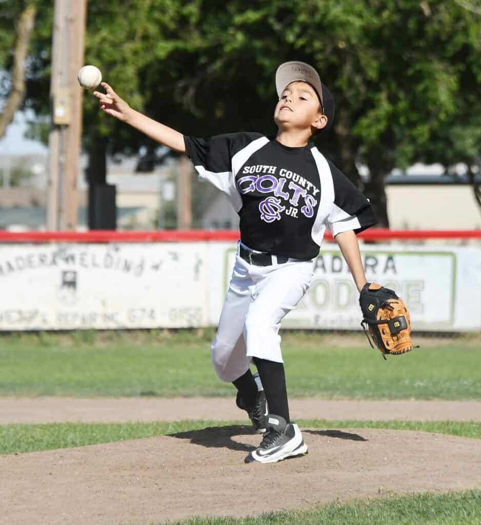 Young South County baseball player pitching during a game.