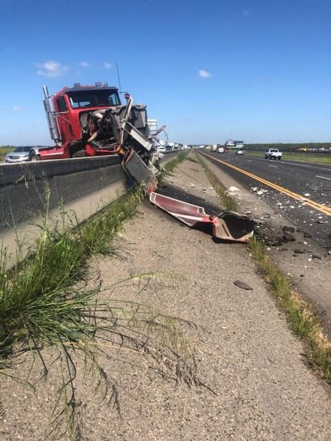 Semi-truck accident on SR 99 highway with debris and damaged guardrail.