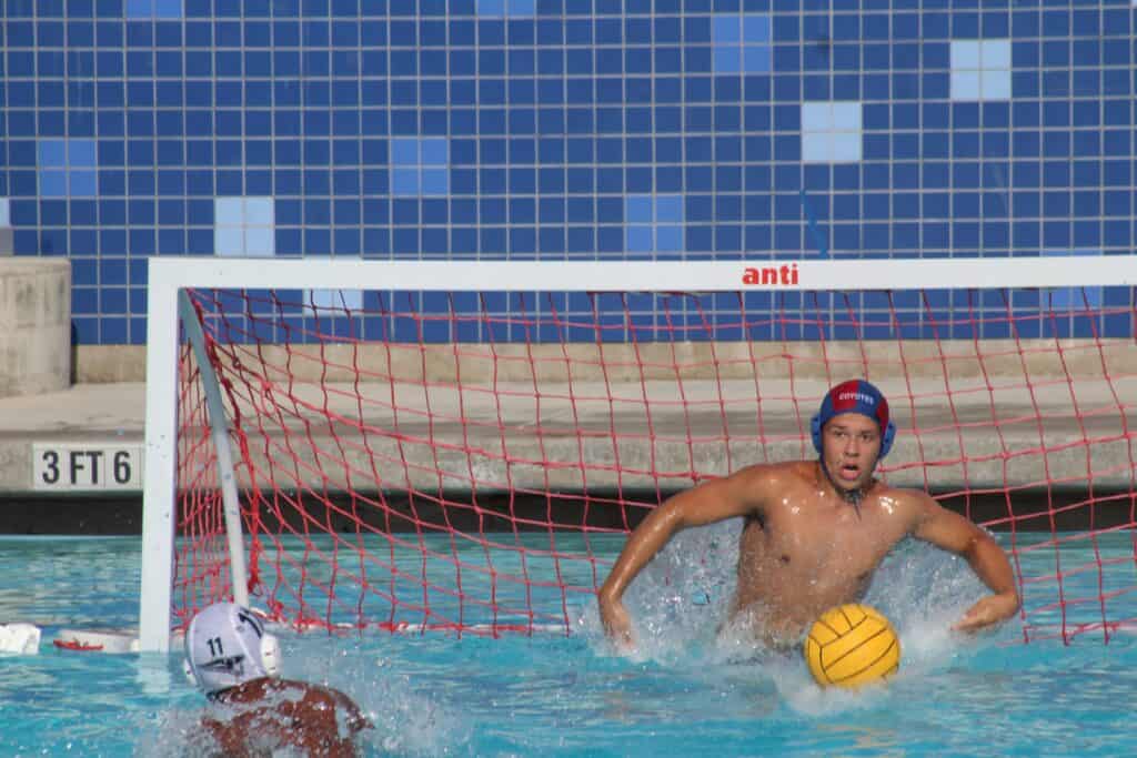 Water polo goalie making a save during a match.