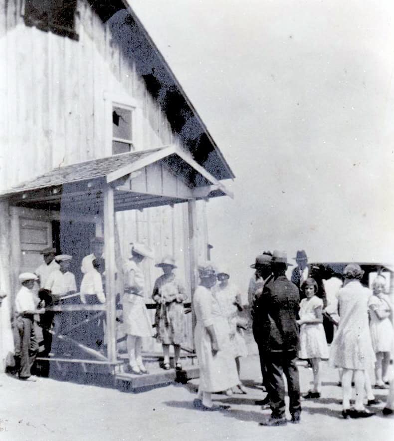 Historic scene of a pioneer preacher cracking a whip during a community gathering.