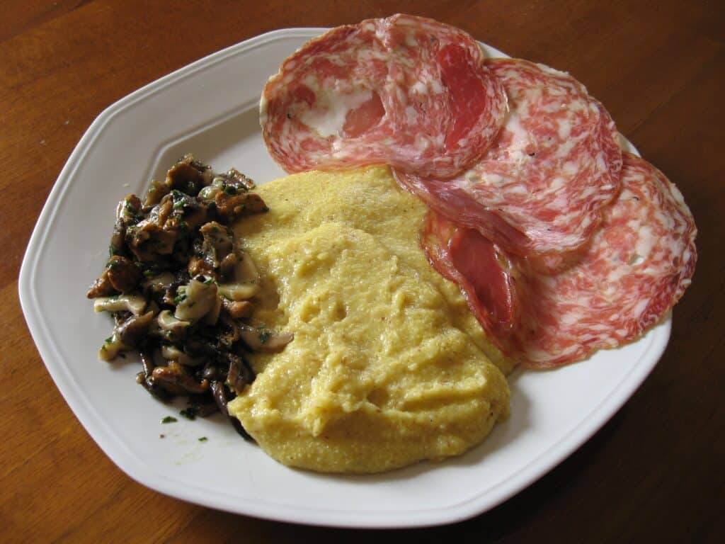 Delicious polenta served with savory salami slices and sautéed mushrooms, perfect for a filling and.