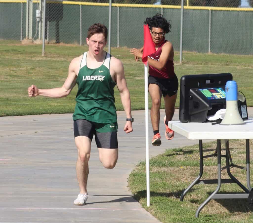Athlete from Liberty High School competes in a relay race at track meet.