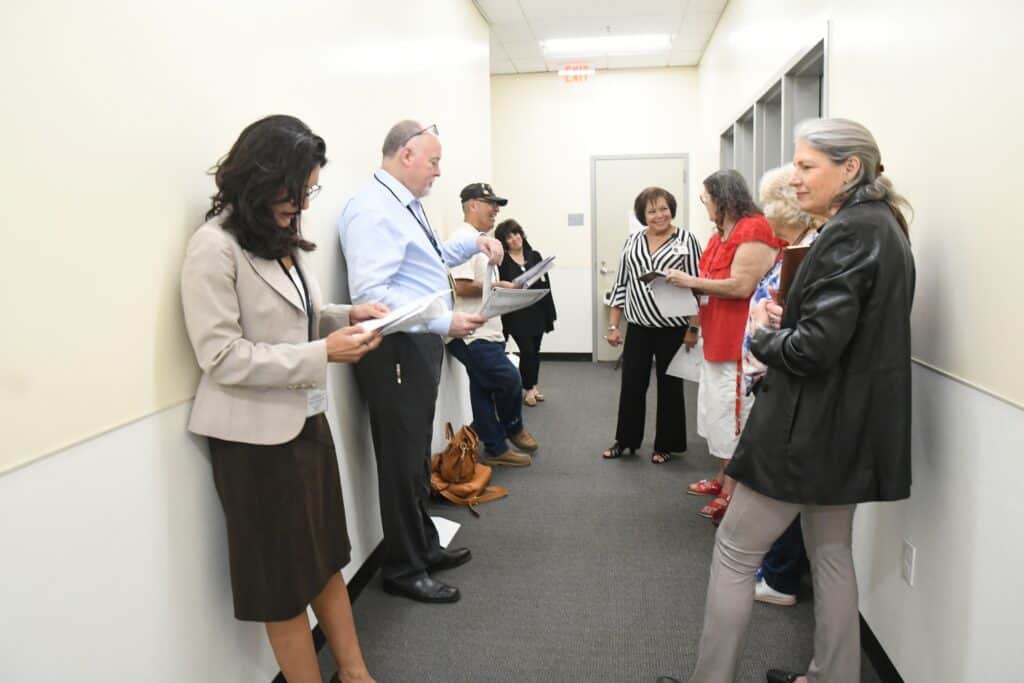 Voters and officials preparing for the Madera recall election in a hallway.