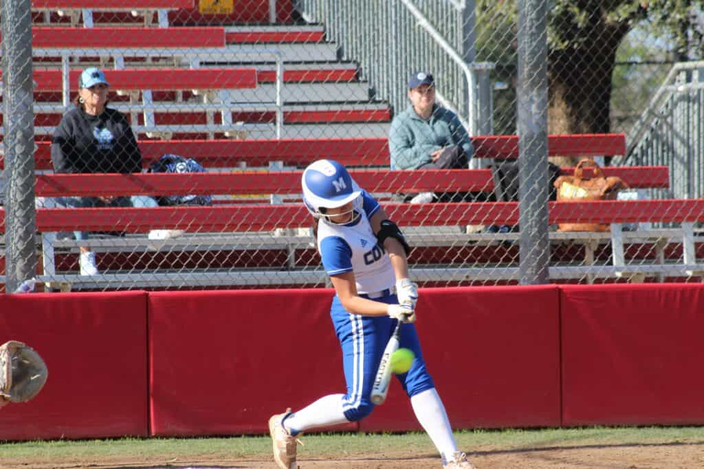 Softball player from Madera team swinging at a pitch during a game.