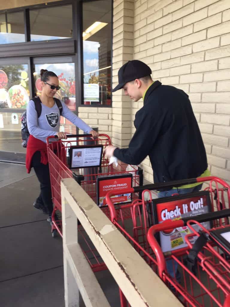 Senior woman shopping with cart outside Save Mart store, social distancing.