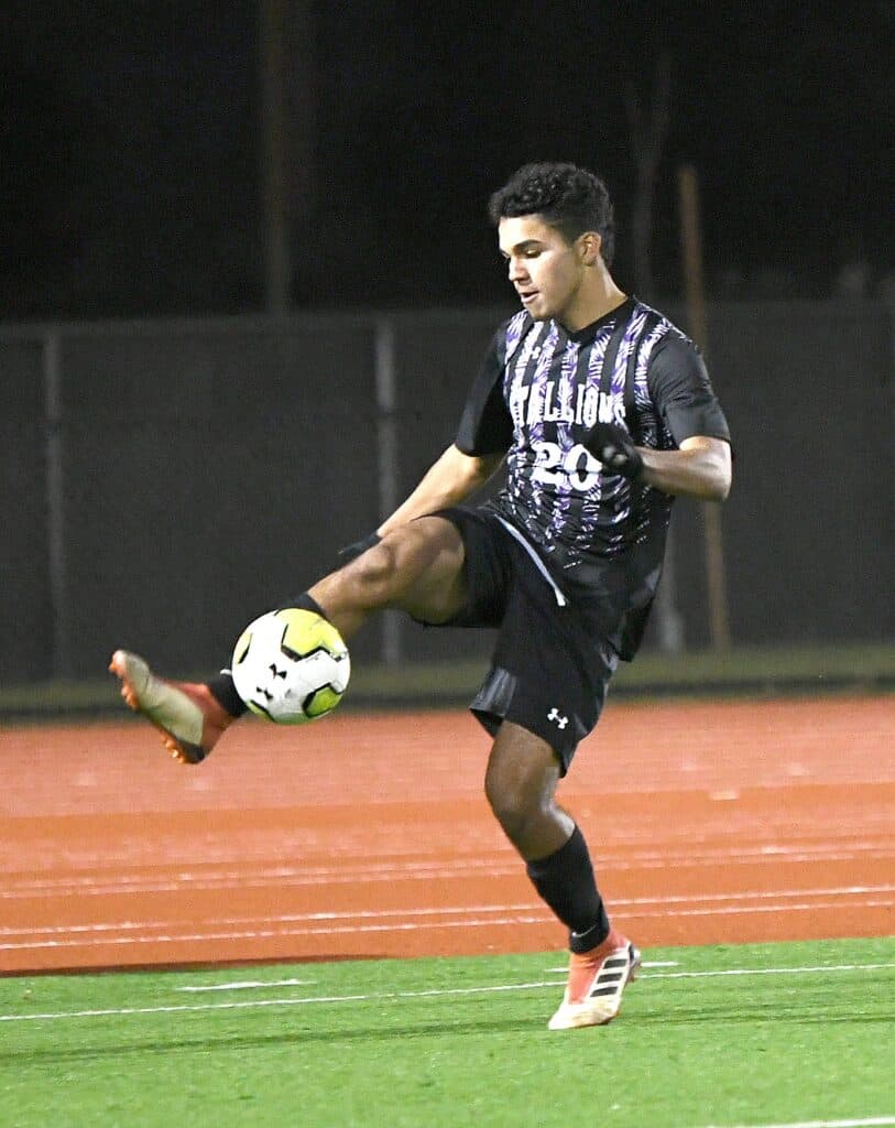 Young male soccer player controlling the ball during a game.