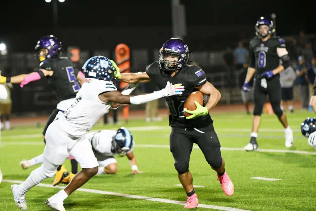 Madera Knights running back evades a tackle during a game.