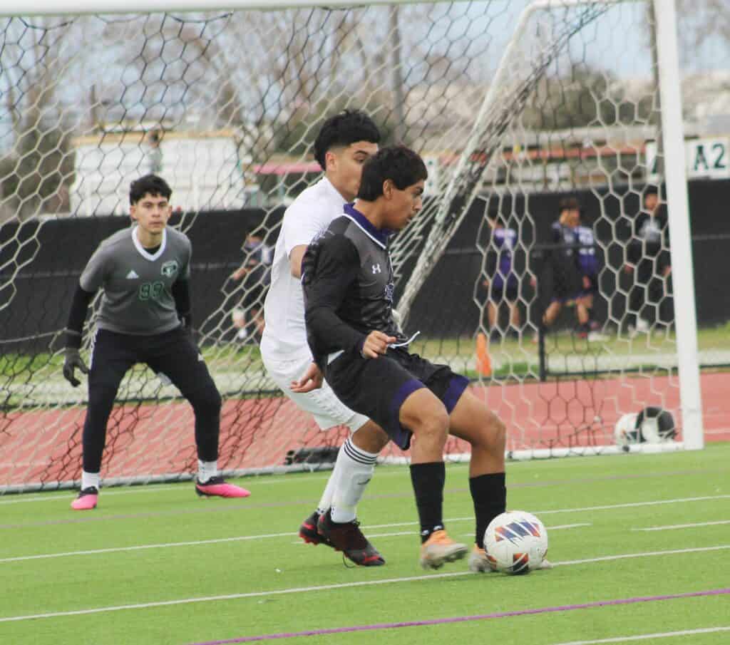Young soccer players battling for ball during overtime match at Madera field.