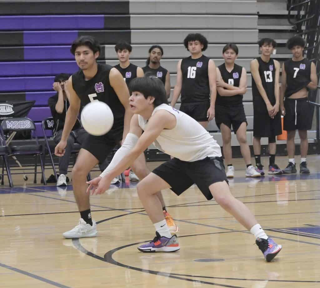 Young volleyball player diving for the ball during practice session.