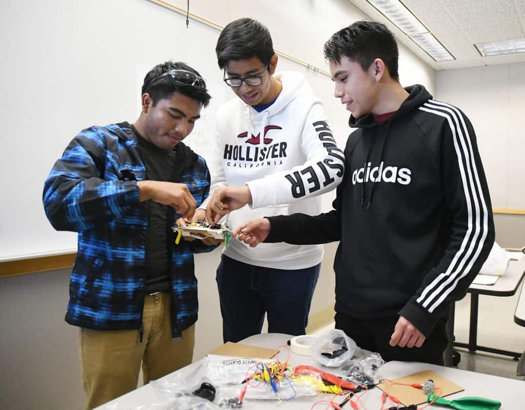 Young students collaborating on a science project for college applications.