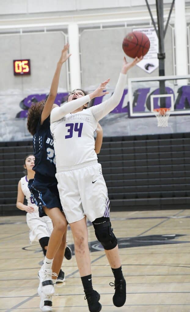 Female basketball player shooting during a game at CMAC.