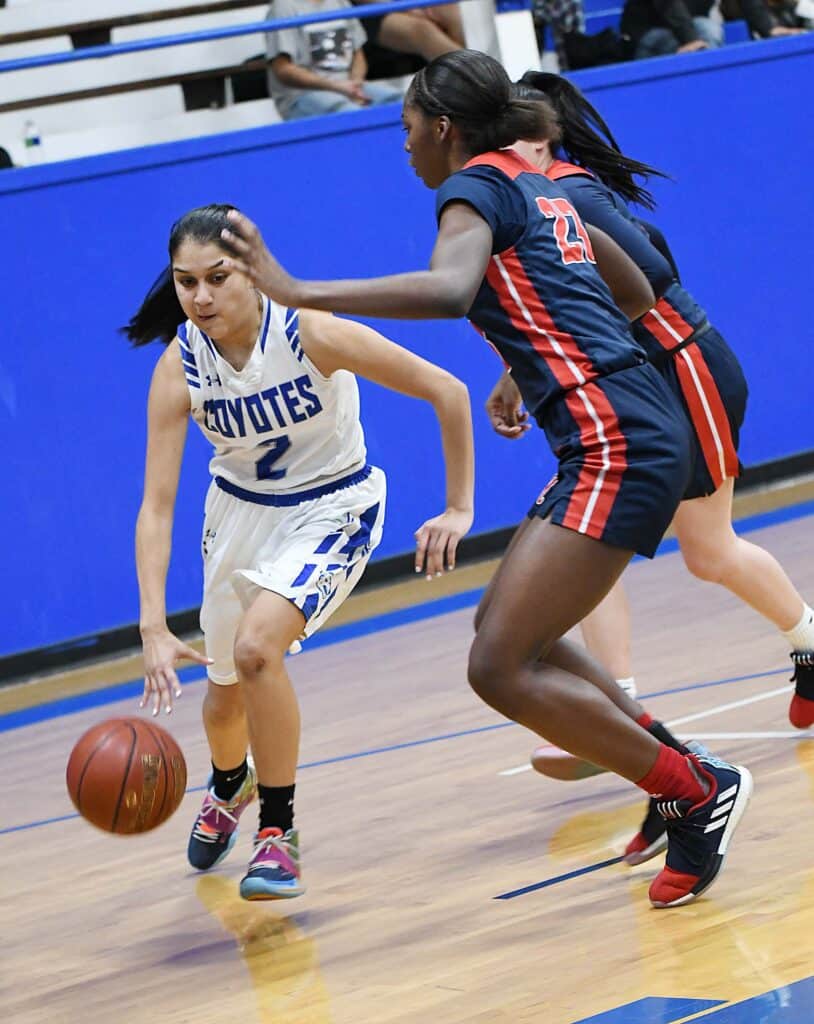 Youth girls basketball game with players competing fiercely on the court.