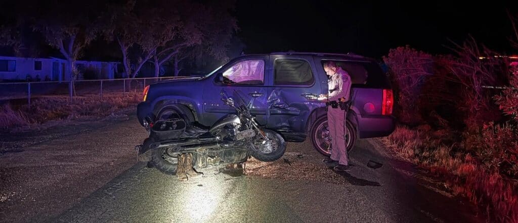 Accident scene involving a motorcycle and a damaged vehicle after a crash.