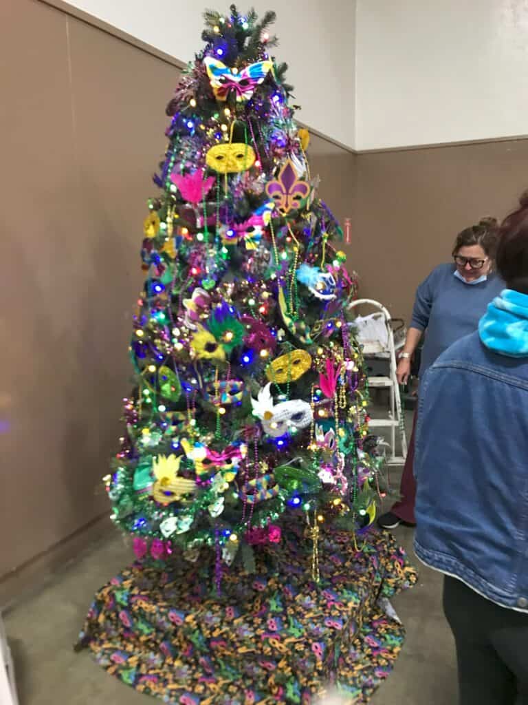 Christmas charity tree decorated with masks and colorful ornaments.