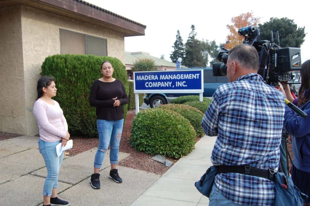 Two women speaking to media outside Madera Management Company office.