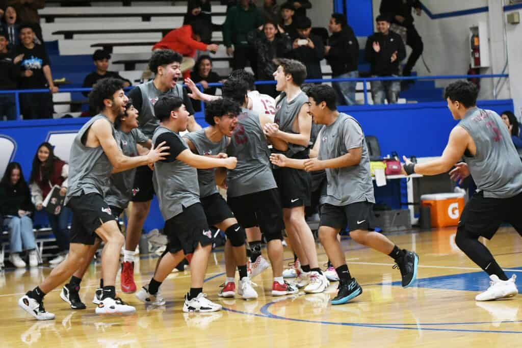 Madera volleyball team celebrating a comeback victory during a match.