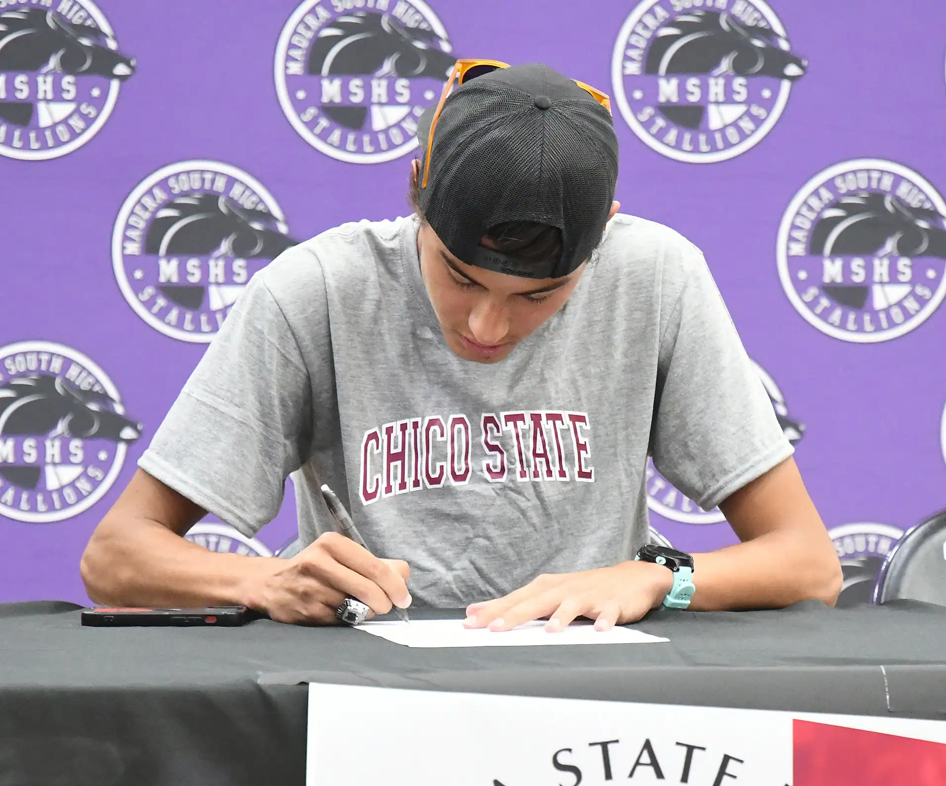 Student signing event at Madera South High School with Chico State shirt.