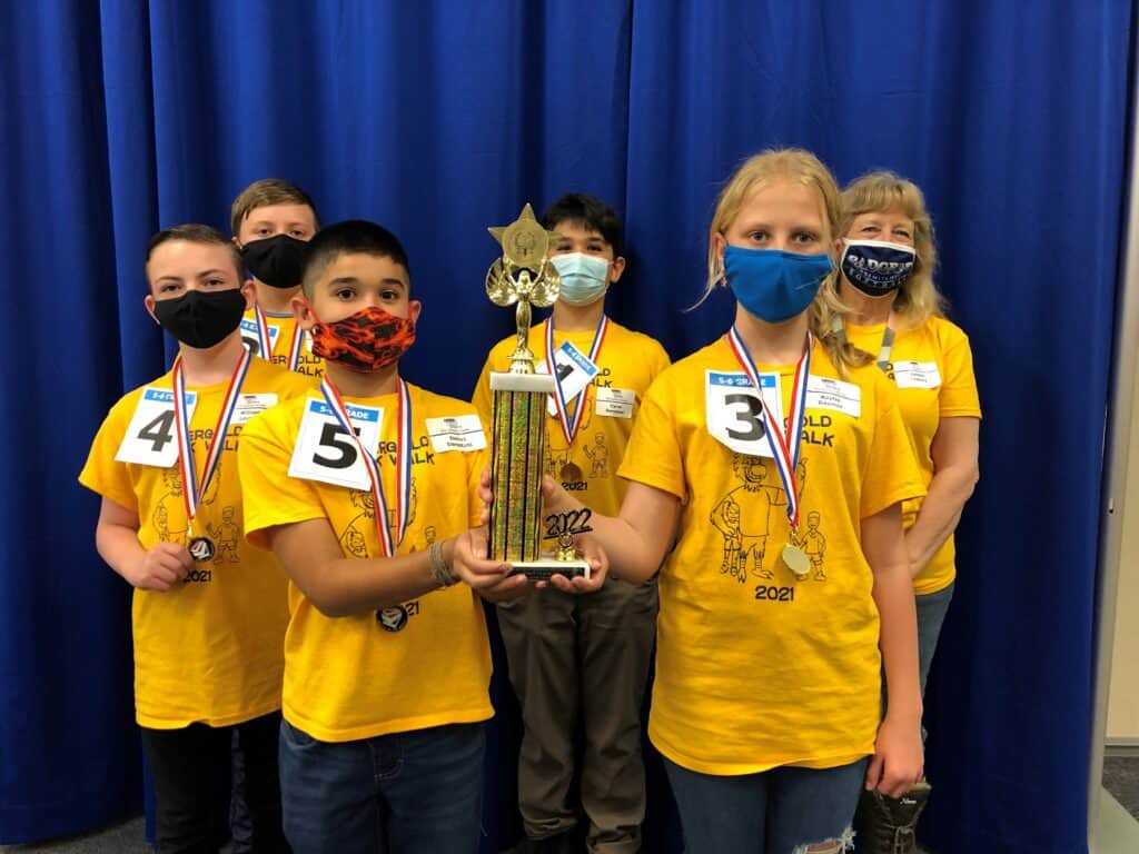 Children holding a trophy at the County Battle of the Books event.