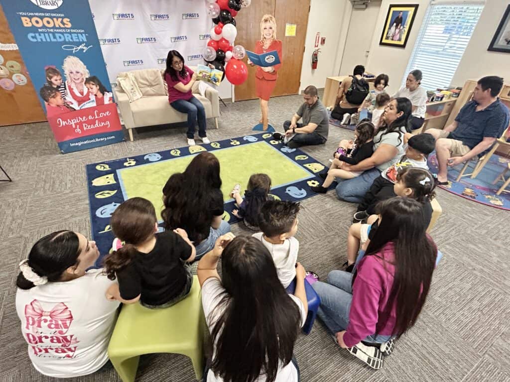 Children and adults participate in a storytime event at the Madera Tribune literacy program.