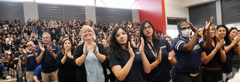 Students and community members clapping and supporting diversity initiatives at a local rally.
