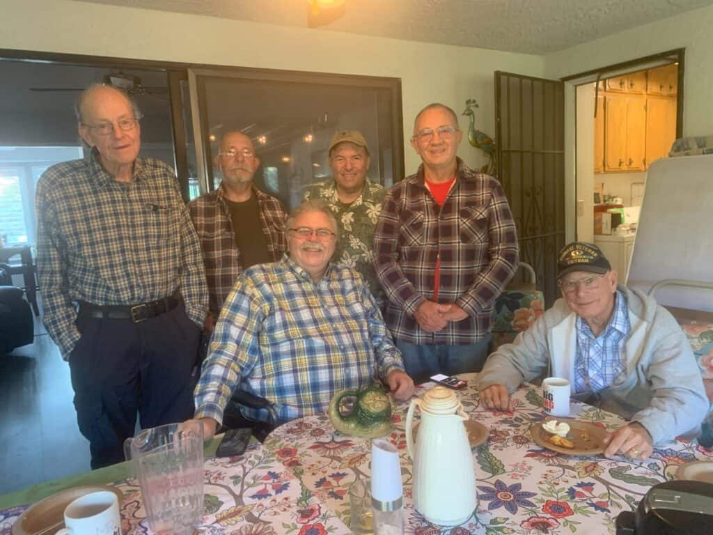 A group of men enjoying coffee and conversation at a community gathering.