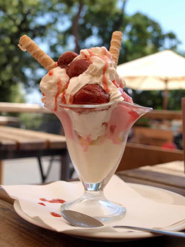 Delicious strawberry sundae with ice cream, strawberries, and toppings in a glass.