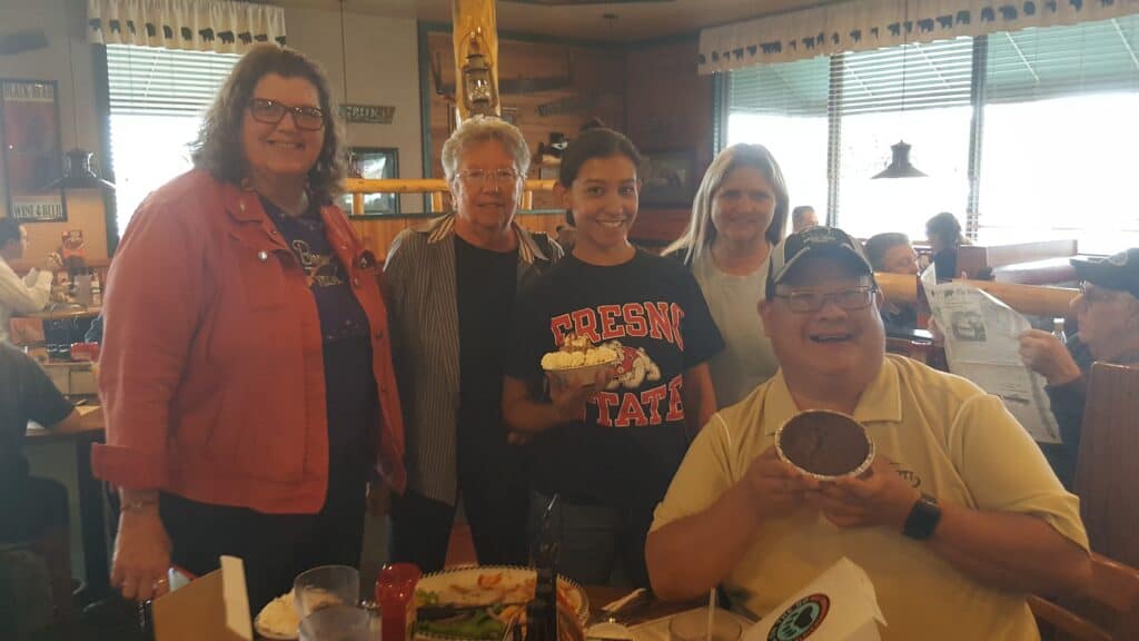 Group of people celebrating Tami Jo Nix with cake and smiles.