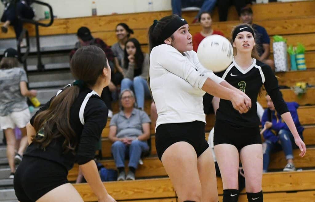 Girls volleyball players in action during a match at Madera gymnasium.