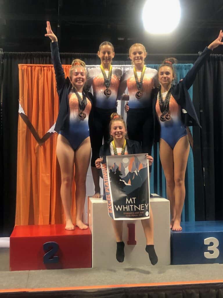 Medal-winning TEC Gymnastics team celebrates victory at competition.