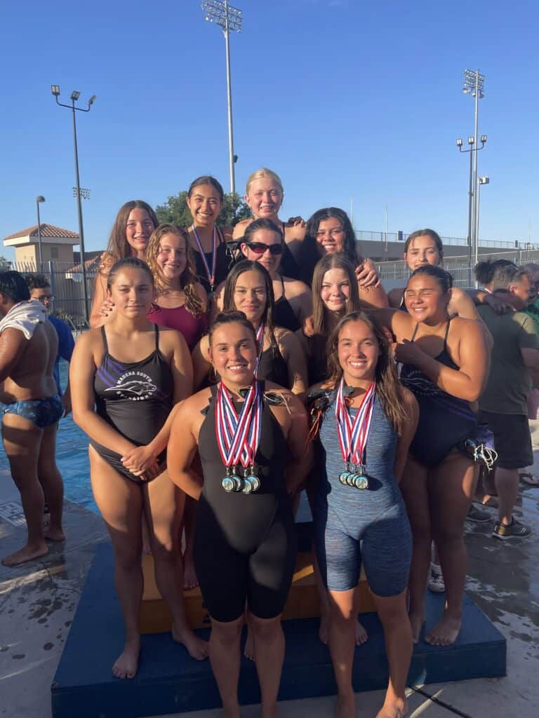 Madera Stallions swim team with medals after winning championship.