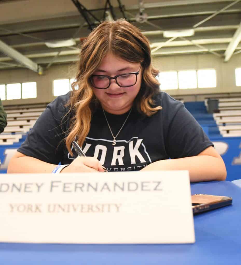 Photo - Top Madera Coyote golfer Sydney Fernandez signs her National Letter of Intent to play golf at York College in Nebraska during the school’s signing ceremony in May.
