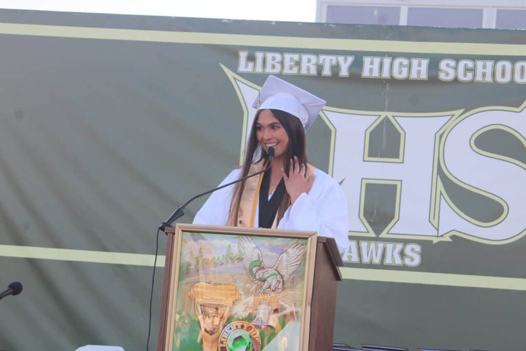 Liberty High School graduate speaking at podium during graduation event.